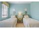 Well-lit bedroom showcasing two twin beds with side table and wall decor at 2611 Little Country Rd, Parrish, FL 34219