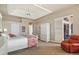 Inviting bedroom features an oversized reading chair, tray ceiling, and access to outdoor living at 2611 Little Country Rd, Parrish, FL 34219