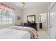 Bright bedroom with a black dresser, a large window, and access to the bathroom at 2611 Little Country Rd, Parrish, FL 34219