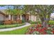 Inviting home entrance with a stone walkway, colorful flower beds, and a beautifully landscaped yard at 2611 Little Country Rd, Parrish, FL 34219