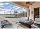 Beautiful screened-in patio with a pool, spa, seating, and a view of the lake at 2611 Little Country Rd, Parrish, FL 34219