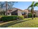 Exterior view of a charming home with lush landscaping, mature trees, and a well-maintained lawn at 5343 Huntingwood Ct # 33, Sarasota, FL 34235