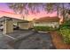 Charming home featuring a terracotta tile roof, covered parking, and lush landscaping during a colorful twilight at 5343 Huntingwood Ct # 33, Sarasota, FL 34235