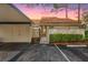 Charming home featuring a terracotta tile roof, covered parking, and gated front entrance during a colorful twilight at 5343 Huntingwood Ct # 33, Sarasota, FL 34235