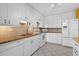 Clean kitchen with white cabinetry, tile flooring, granite countertops, and updated appliances at 5343 Huntingwood Ct # 33, Sarasota, FL 34235