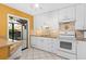 Functional kitchen with white cabinetry, tile flooring, granite countertops, and modern white appliances at 5343 Huntingwood Ct # 33, Sarasota, FL 34235