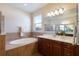 Elegant bathroom with a large soaking tub, glass-enclosed shower, and double vanity with a granite countertop at 6914 45Th E Ter, Bradenton, FL 34203