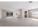 Bright, open-concept living area featuring sliding glass doors, neutral carpet, and a kitchen view at 6914 45Th E Ter, Bradenton, FL 34203
