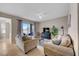 Relax in this cozy living room featuring neutral tones, plush seating, and sliding doors to a scenic balcony at 7911 Grand Estuary Trl # 106, Bradenton, FL 34212