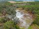 Picturesque aerial view of the rural property bordered by verdant woods showcasing an animal enclosure at 8107 High Oaks Trl, Myakka City, FL 34251