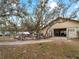 The barn's exterior is surrounded by mature trees and an enclosed chicken coop at 8107 High Oaks Trl, Myakka City, FL 34251