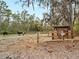 Rustic horse property featuring sturdy fencing, grazing livestock, and a quaint, shaded shelter at 8107 High Oaks Trl, Myakka City, FL 34251