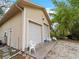Garage exterior features two garage doors, seating, and outdoor lantern at 8107 High Oaks Trl, Myakka City, FL 34251