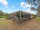 Exterior view of pool and patio area, showcasing the outdoor living spaces, the enclosure, and landscaping at 8107 High Oaks Trl, Myakka City, FL 34251