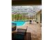 Screened-in pool area offers a relaxing retreat with a view of the backyard and patio furniture at 8107 High Oaks Trl, Myakka City, FL 34251