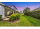 Spacious backyard featuring a screened patio, lush green lawn, and privacy hedges at 12810 Seasong Ter, Bradenton, FL 34211