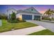 Exterior view showcasing a three-car garage, manicured lawn, and beautiful landscaping at 12810 Seasong Ter, Bradenton, FL 34211