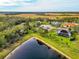 Picturesque aerial view of a neighborhood house near lake featuring lush landscape, and sparkling lake at 16806 5Th Ne Ter, Bradenton, FL 34212