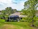 Aerial view of a home with a screened-in pool, lush landscaping, and mature trees at 16806 5Th Ne Ter, Bradenton, FL 34212