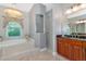 A bright bathroom features a soaking tub, walk-in shower, and vanity with granite countertops at 16806 5Th Ne Ter, Bradenton, FL 34212