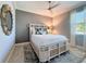 Cozy bedroom with neutral tones, accent wall, a decorative mirror and a ceiling fan at 16806 5Th Ne Ter, Bradenton, FL 34212