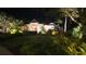Beautiful home exterior at night featuring landscape lighting, manicured lawn and mature tropical plants at 16806 5Th Ne Ter, Bradenton, FL 34212
