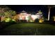 Inviting home exterior at night showcasing landscape lighting, lush green lawn and manicured shrubbery at 16806 5Th Ne Ter, Bradenton, FL 34212