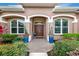 Inviting front entrance with lush landscaping, arched doorway, and decorative planters flanking the door at 16806 5Th Ne Ter, Bradenton, FL 34212
