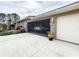View of a three-car garage with a screened-in opening, a white car inside, and manicured landscaping outside at 16806 5Th Ne Ter, Bradenton, FL 34212