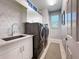 Well-equipped laundry room features a sink, counter space, storage cabinets and high-end washer and dryer at 16806 5Th Ne Ter, Bradenton, FL 34212