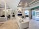 Elegant living room with tray ceilings, open floor plan, electric fireplace and sliding glass doors to outdoor area at 16806 5Th Ne Ter, Bradenton, FL 34212