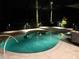 Tranquil pool view at night with inset spa and stone surround, featuring underwater lighting at 16806 5Th Ne Ter, Bradenton, FL 34212