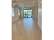 Bright living room with wood-look tile flooring and a sliding glass door leading to a lake view at 204 Villoresi Blvd, Nokomis, FL 34275
