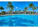 A large, inviting pool with pristine blue water, palm trees, and a community clubhouse in the backdrop at 204 Villoresi Blvd, Nokomis, FL 34275
