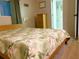 Comfortable bedroom with a bright floral comforter and a view of the bathroom area at 2107 Palma Sola Blvd # 27, Bradenton, FL 34209