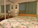 Cozy bedroom featuring a tropical-themed quilt, mirrored closet, and ample natural light at 2107 Palma Sola Blvd # 27, Bradenton, FL 34209