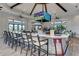 Stylish bar area featuring a large TV, modern stools, and elegant countertops for entertainment at 6739 Haverhill Ct, Lakewood Ranch, FL 34202