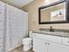 Bathroom features a granite vanity top, white cabinet, and shower with patterned curtain at 1382 Ronald St, North Port, FL 34286