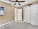 Carpeted bedroom with neutral walls, ceiling fan, and closet access; move-in ready at 1382 Ronald St, North Port, FL 34286