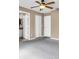 Bedroom with neutral walls, carpeting, and ceiling fan near bathroom and closet at 1382 Ronald St, North Port, FL 34286