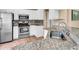 Modern kitchen boasts stainless steel appliances, granite countertops, and white cabinets at 1382 Ronald St, North Port, FL 34286
