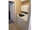 Functional laundry room featuring a washer, dryer, storage cabinets, and access door to the outside at 1382 Ronald St, North Port, FL 34286