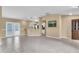 Open floorplan showcasing gray tile flooring, neutral walls, and connection to kitchen at 1382 Ronald St, North Port, FL 34286