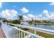 Enjoy the beautiful water views from this balcony with a railing, palm trees, and blue sky at 1389 Tangier Way, Sarasota, FL 34239