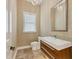 Modern powder room with unique sink, dark wood cabinetry, tiled floor, and decorative wall lighting at 1389 Tangier Way, Sarasota, FL 34239