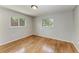 Bedroom featuring hardwood floors, neutral walls, and natural light from two windows at 2299 Riverwood Ct, Sarasota, FL 34231