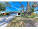 Charming single-story blue home with a large front yard and mature landscaping at 2299 Riverwood Ct, Sarasota, FL 34231