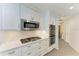 Modern kitchen featuring white cabinetry, stainless appliances, and herringbone backsplash at 2299 Riverwood Ct, Sarasota, FL 34231