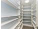 Spacious walk-in pantry featuring custom shelving and tile flooring at 2299 Riverwood Ct, Sarasota, FL 34231