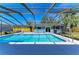 Outdoor pool with screen enclosure and clear blue sky at 2299 Riverwood Ct, Sarasota, FL 34231